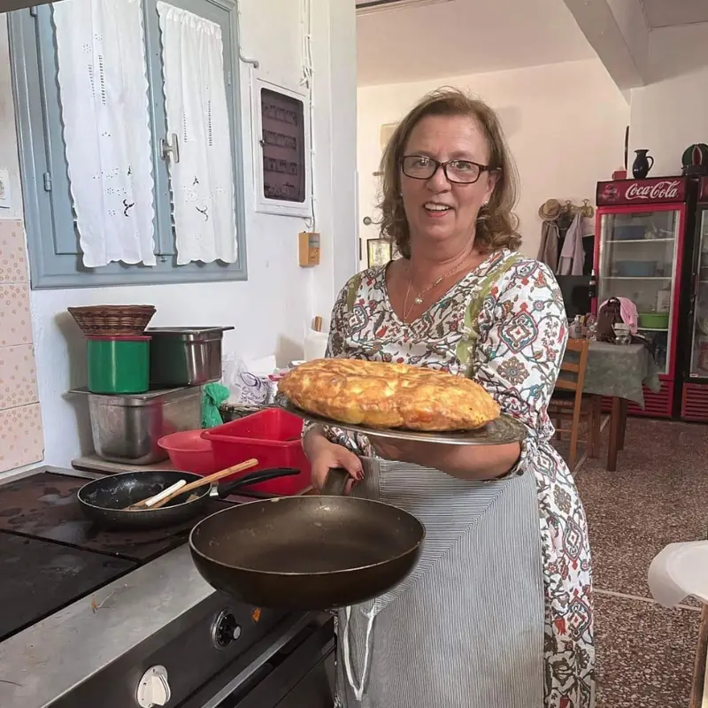 Μαγείρισσα κρατά ταψί με πίτα σε κουζίνα